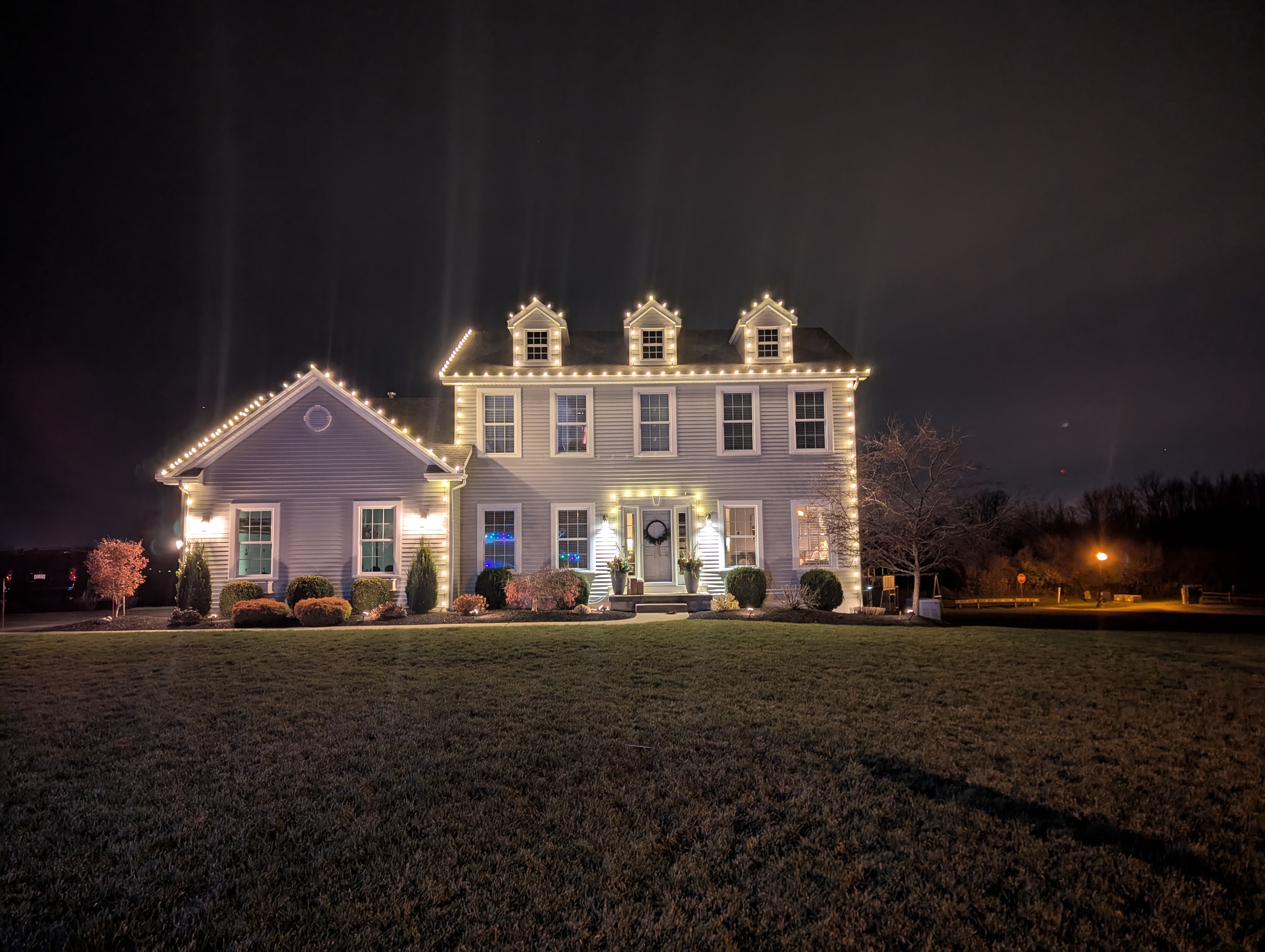 Warm-white architectural Christmas lighting on a large home